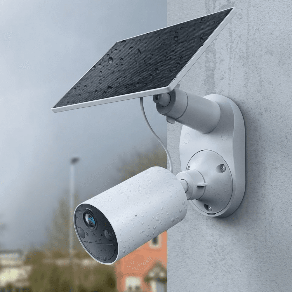 Solar-powered security camera with panel mounted on an exterior wall